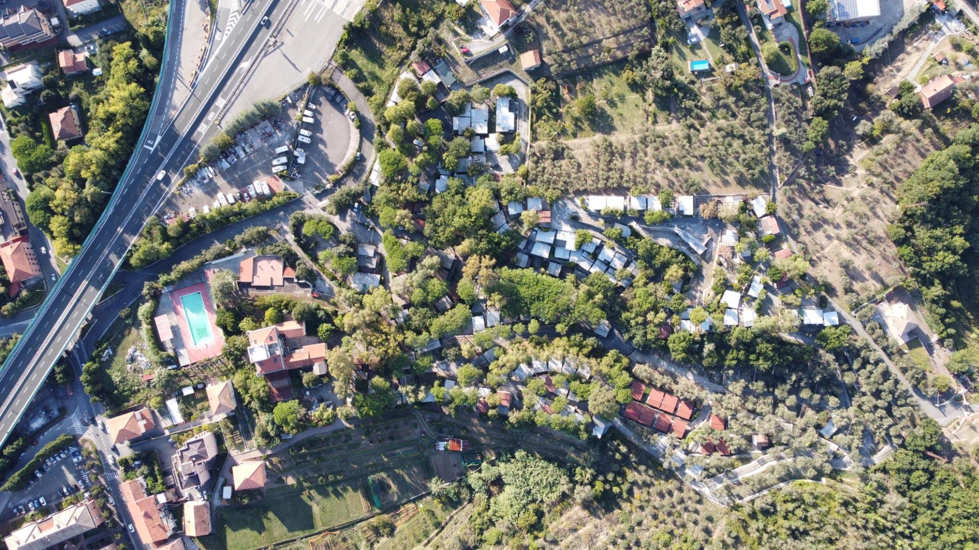 Vista aerea di una zona residenziale con piscina e strade.
