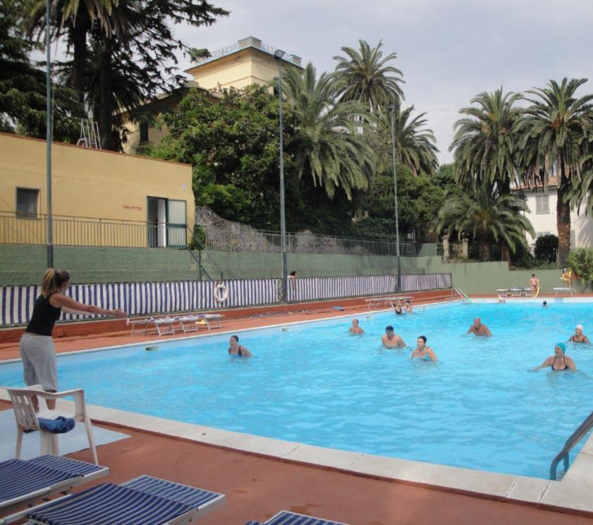 Aquagym-Kurs im Pool mit Trainer und Teilnehmern.