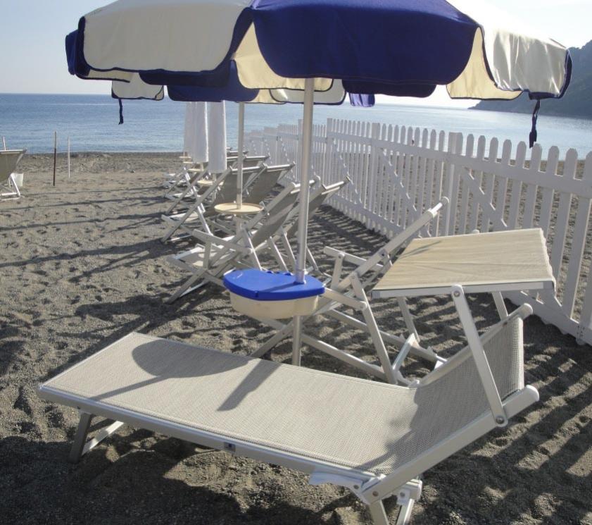 Strand mit Liegen, blauen Sonnenschirmen und weißem Zaun.